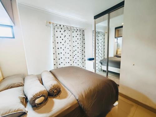a bedroom with a bed with pillows and a mirror at Flo's Transit Home in Manado