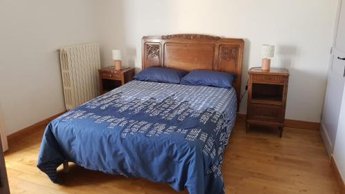 a bedroom with a bed with a blue comforter at La truffière in Belvès