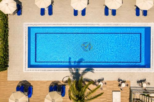 an overhead view of a swimming pool with people around it at Nautilos Hotel in Soullároi