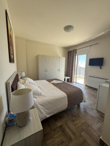 a bedroom with a bed and a table with a lamp at Blue House- Peaceful Mountain Escape in Mazraat et Teffâh