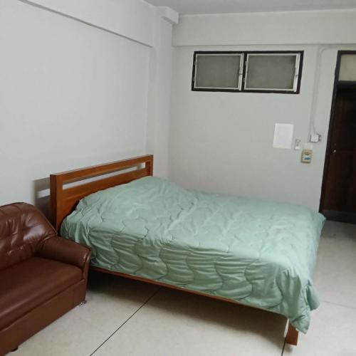 a small bedroom with a bed and a couch at Viriyapon in Bangkok