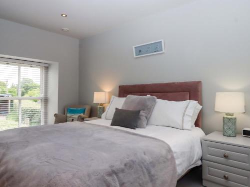 a bedroom with a large bed and a window at Duke's Barn in Totnes
