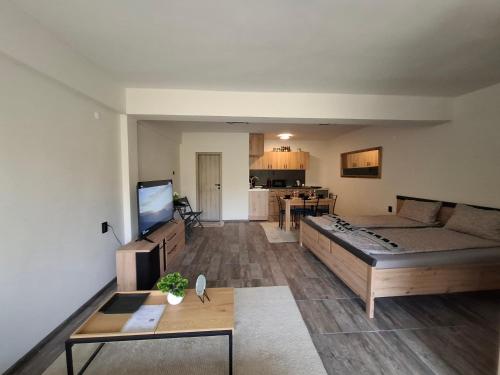 ein Wohnzimmer mit Sofa und Tisch in der Unterkunft Apartment Maliva in Weliko Tarnowo