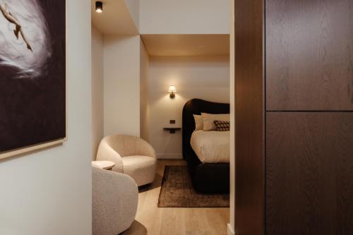 a small room with a bed and a chair and a bedroom at Sola Studios in Margaret River Town