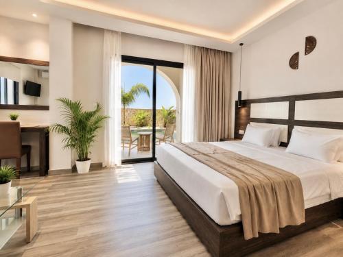 a bedroom with a large bed and a balcony at ABATON Luxury Resort in Tsilivi