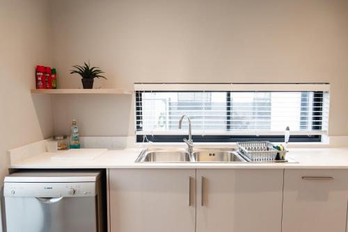 a white kitchen with a sink and a window at Hole Inn 1 in Robertson