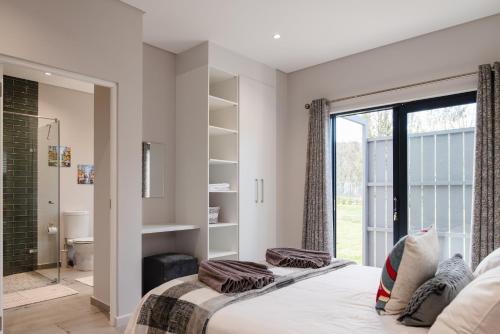 a bedroom with a bed and a large window at Hole Inn 1 in Robertson