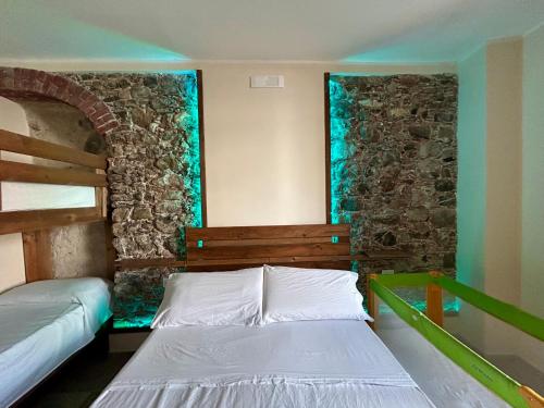 ein Schlafzimmer mit einem Bett und einer Steinwand in der Unterkunft Gemma Maris in Sapri