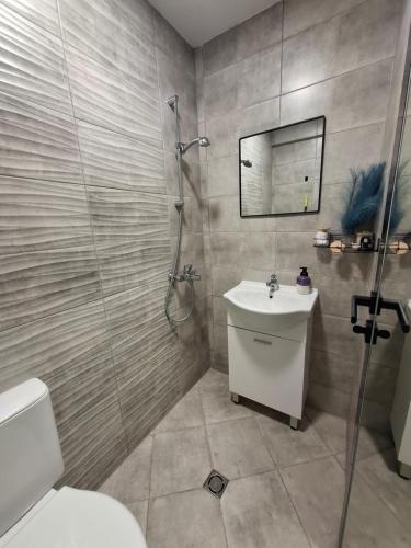 ein Badezimmer mit Dusche, Toilette und Waschbecken in der Unterkunft Apartment Maliva in Weliko Tarnowo