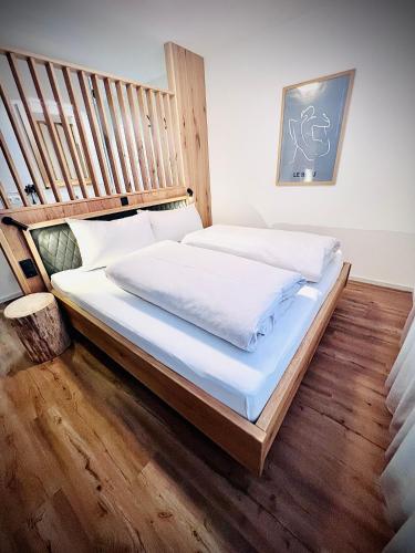 a bedroom with a large bed with a wooden headboard at HOLZLODGE APARTMENTS - Alpine Living in Radstadt - Salzburger Sportwelt in Radstadt