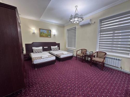 a bedroom with a bed and a couch and chairs at Grand Silk Road in Samarkand
