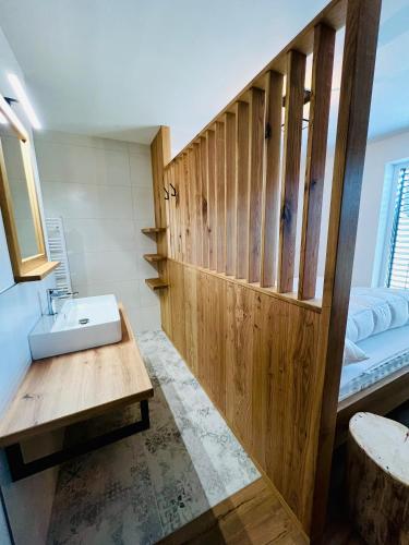 a bathroom with a sink and a wooden wall at HOLZLODGE APARTMENTS - Alpine Living in Radstadt - Salzburger Sportwelt in Radstadt