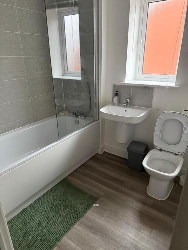 a bathroom with a toilet and a sink and a shower at Aries de Baldock in Canterbury