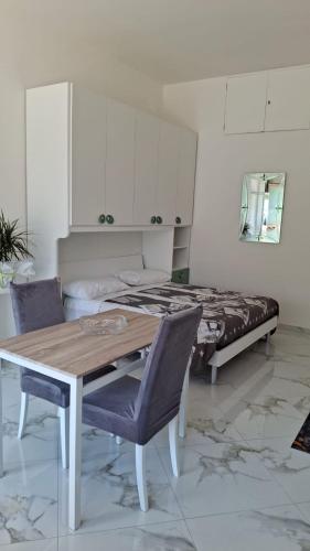 a room with a table and chairs and a bed at Skizzo residence in Santa Maria degli Angeli