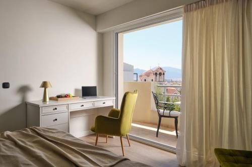 a bedroom with a bed and a desk and a window at Civitel Attik Rooms & Suites in Athens