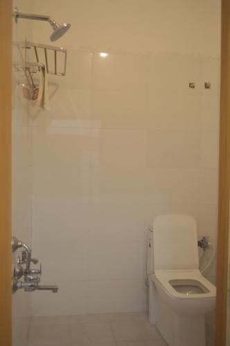a white bathroom with a toilet and a shower at Hotel Vijanta Banquet in Sasarām