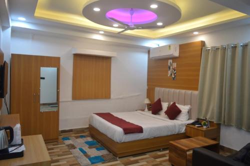 a bedroom with a bed with a purple light on the ceiling at Hotel Vijanta Banquet in Sasarām