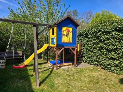 a playground with a house and a swing at Zinnowitz, Haus Jörn in Zinnowitz