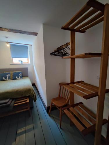 a bedroom with a bunk bed and a chair and a ladder at The Courtyard Hideout in Hereford