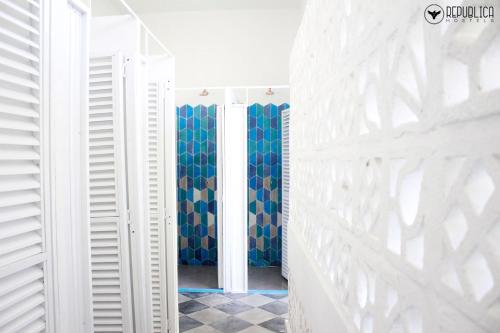 un pasillo con paredes blancas y cortinas azules en República Hostel Cartagena, en Cartagena de Indias