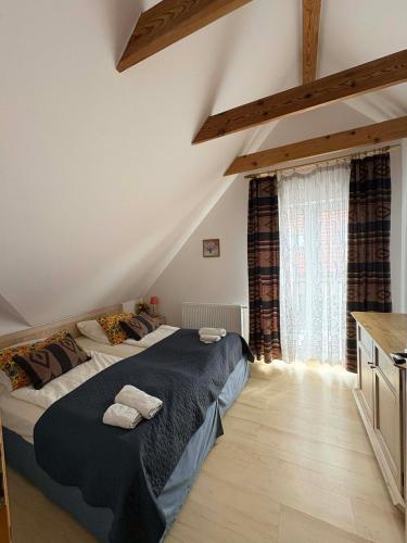 a bedroom with a large bed in a attic at Polanki10 Łebski Dworek u Anity in Nowęcin