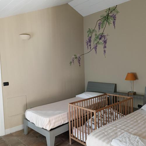 a bedroom with two beds and a plant on the wall at B&B La Quercia in Moncalvo