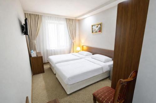 a hotel room with a bed and a chair at Gyumri Hotel in Gyumri
