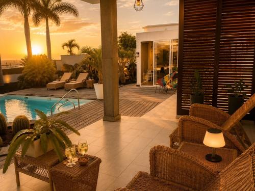 a patio with wicker chairs and a swimming pool at Villa Claus - Private Pool Oasis in Puerto Calero in Puerto Calero