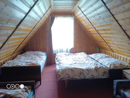 two beds in a room with a window at Chatička For Funny in Horní Slavkov