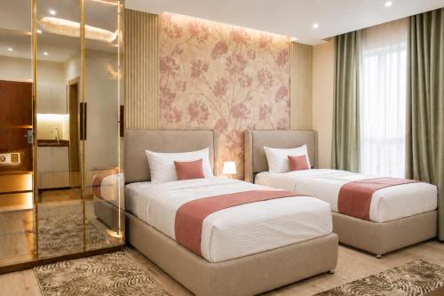 a hotel room with two beds and a mirror at Stay Inn 51 Hotel Zayed in Sheikh Zayed