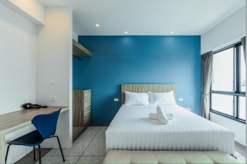 a bedroom with a large bed with a blue wall at ABC@48 Hotel & Service Apartment in Bangkok