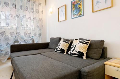 a living room with a gray couch with pillows at Fontanine House in Rapallo