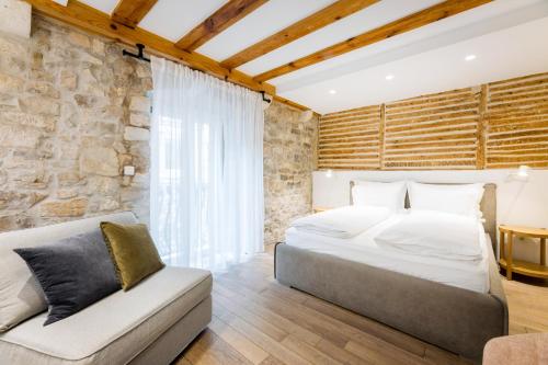 a bedroom with a king sized bed and a couch at Grgur Ninski Rooms in Split