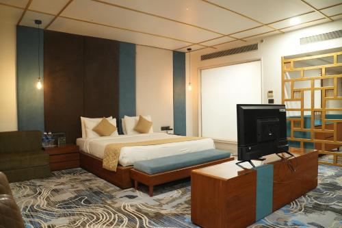 ein Hotelzimmer mit Bett und Fernseher in der Unterkunft Devka Beach Resort in Daman