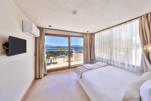 a bedroom with a bed and a large window at yazz inn in Kaş