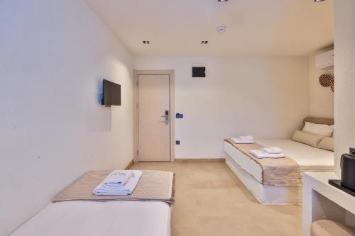 a small room with two beds and a tv at yazz inn in Kaş
