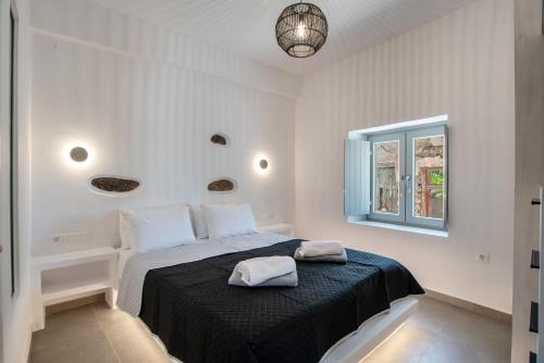 ein Schlafzimmer mit einem Bett mit schwarzer Decke und einem Fenster in der Unterkunft Næxon in Vívlos