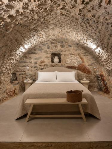 a bedroom with a bed in a stone wall at Agrià XVII Mani Stone Tower in Kotráfion