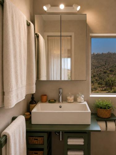 a bathroom with a sink and a mirror and a window at Agrià XVII Mani Stone Tower in Kotráfion