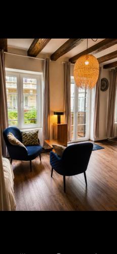 a living room with two chairs and a chandelier at La Terrasse Desaix in Strasbourg