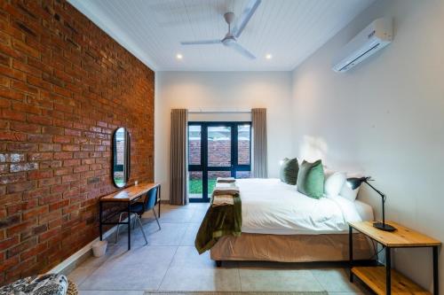 a bedroom with a bed and a brick wall at The Pods Victoria Falls in Victoria Falls