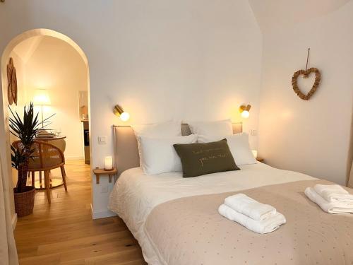 a bedroom with a large bed with two towels on it at La Chaumière des Marais Escapade romantique & jacuzzi privatif in La Chapelle-des-Marais