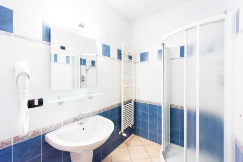 a bathroom with a sink and a shower at Hotel Bacco in Beinette