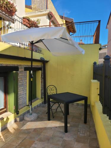 a black table and a white umbrella on a patio at Ca'del Porto in Marano Lagunare