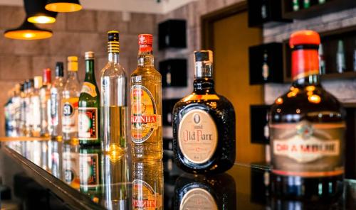 a group of bottles of alcohol on a bar at Ibiza Plaza Hotel in Anápolis