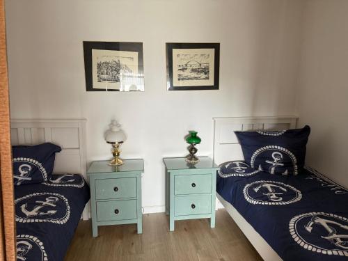 a bedroom with two beds and two night stands at Apartments in Heiligenhafen