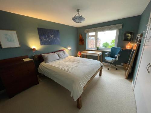 a bedroom with a bed and a desk and a chair at Mid-Century Gem Steps from the Beach in Edinburgh