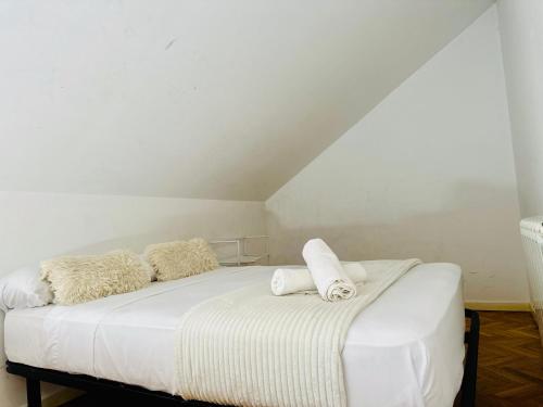 a white bed with two pillows on top of it at Pisos Baraja Gl in Madrid