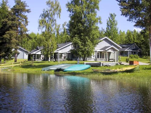 a house with boats on the shore of a lake at Marttinen in Virrat