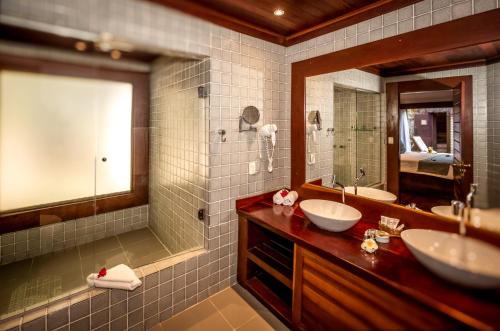 a bathroom with two sinks and a large mirror at Sombra e Água Fresca Resort in Pipa